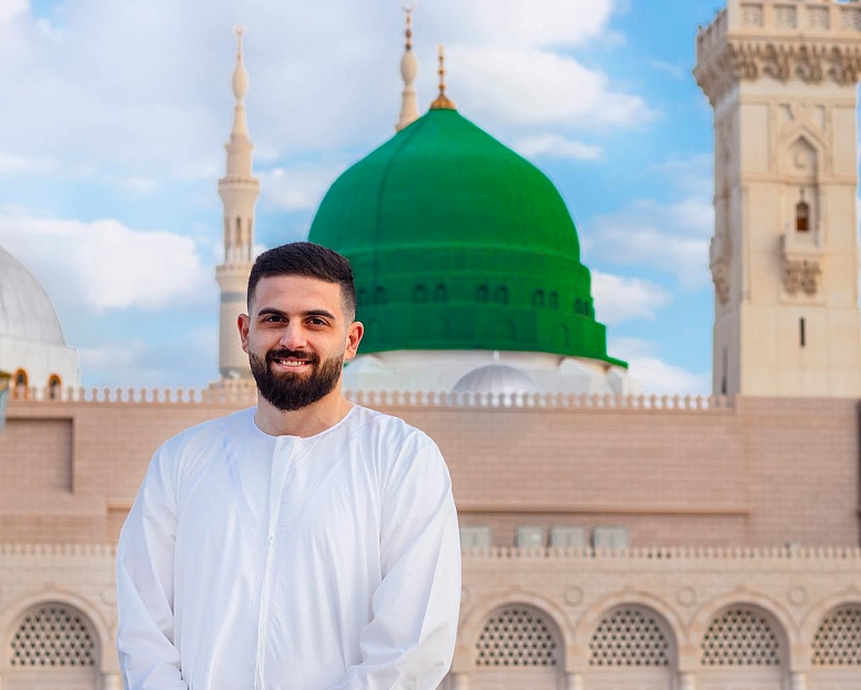 man in white thobe standing near masjid e nabwi